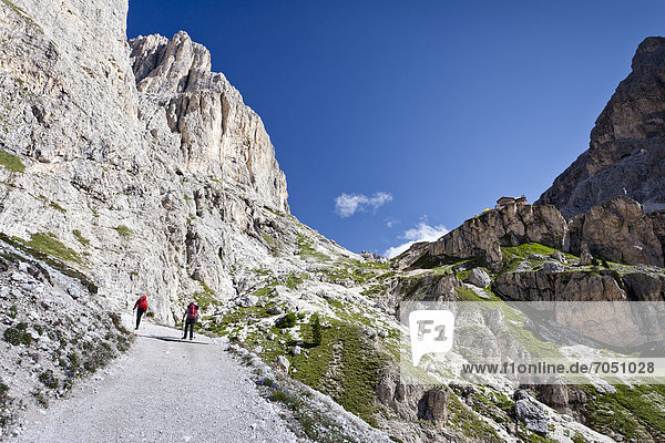 Hikers during the ascent to Kesselkogel Mountain above the Rifugio Gardecia hut  Rosengarten Group and Rifugio Preuss hut at the rear  Trentino  Italy  Europe