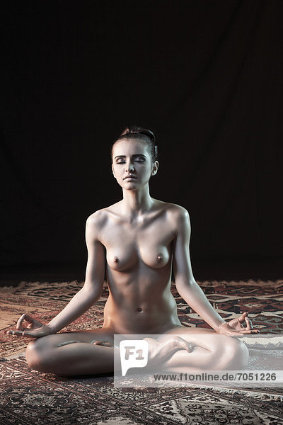 Junge Frau im Lotussitz  nackt  Yoga-Pose