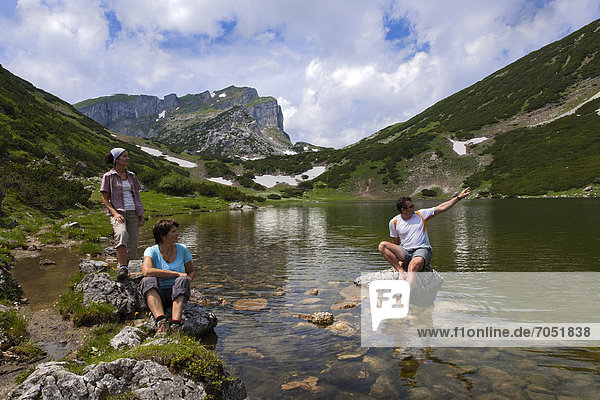 Hikers at a mountain lake  Lake Zireiner  Kramsach  Rofan Mountains  Tyrol  Austria  Europe