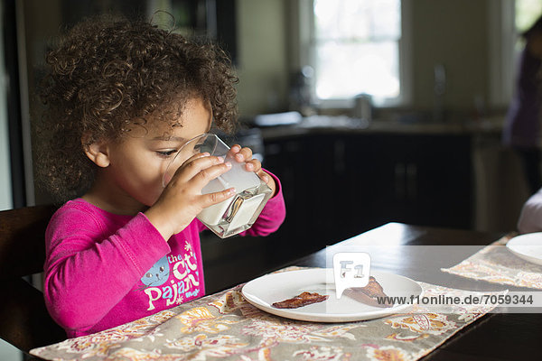 Mixed race girl drinking milk