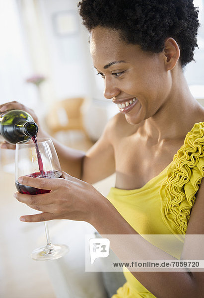 African American woman pouring red wine