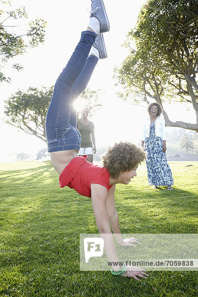 African American family watching girl do a handstand