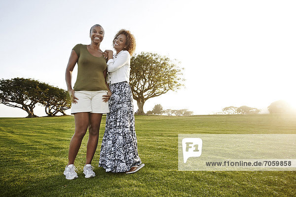 African American mother and daughter standing in park