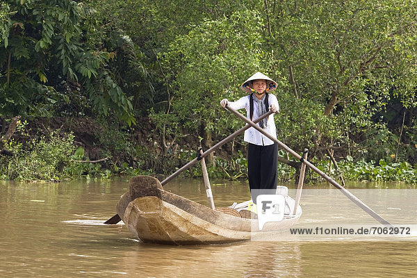Eine Vietnamesien rudert durch einen Seitenarm des Mekongfluss Mekongdelta Vietnam