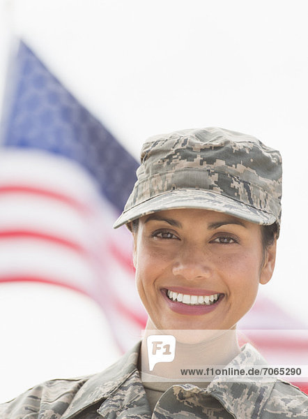 Portrait of female army soldier  American flag in background
