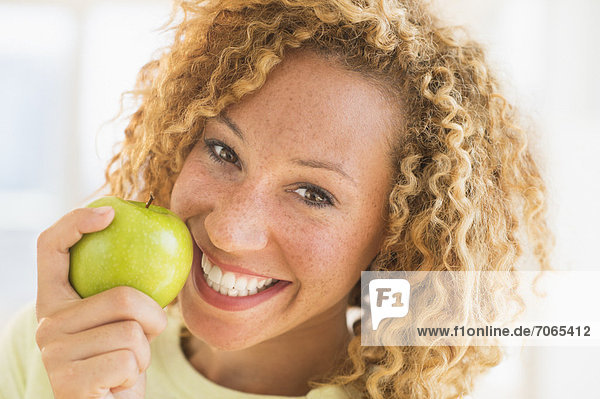 Portrait of smiling young woman with apple