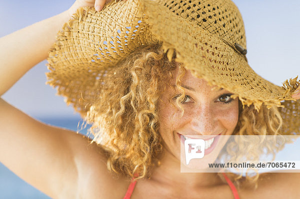 Portrait of smiling young woman in sun hat