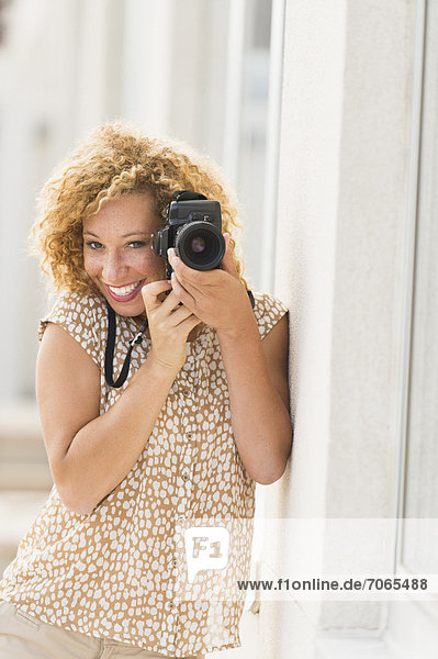 Portrait of young woman holding camera