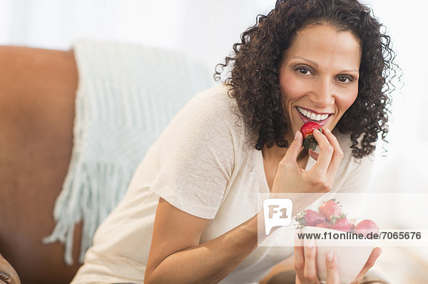 Portrait of woman eating strawberries