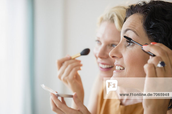 Female friends during applying make-up