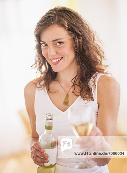 Woman holding wine bottle and glass