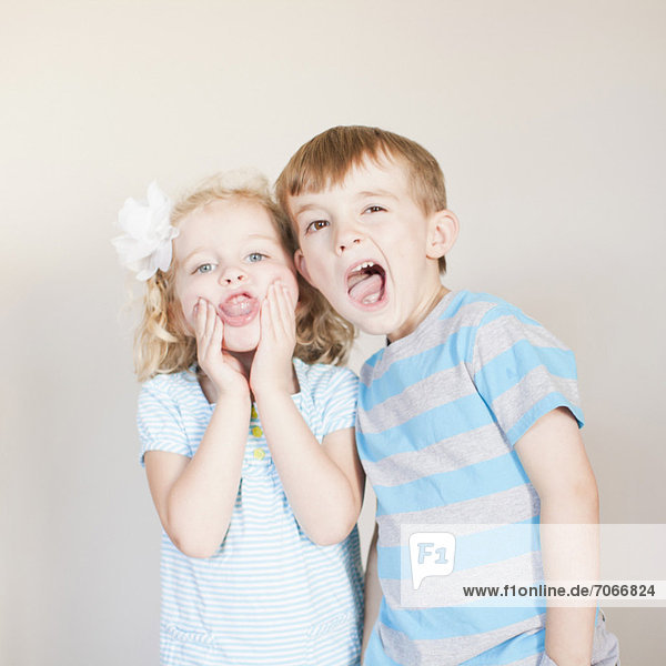 Studio Shot  Portrait of girl and boy making faces