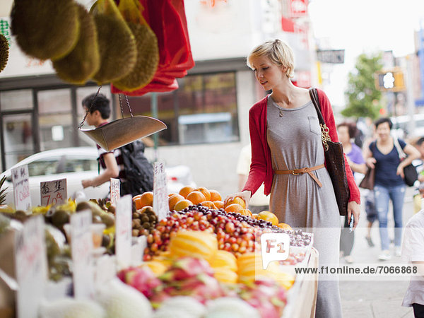 Woman looking at fresh friuts at street market