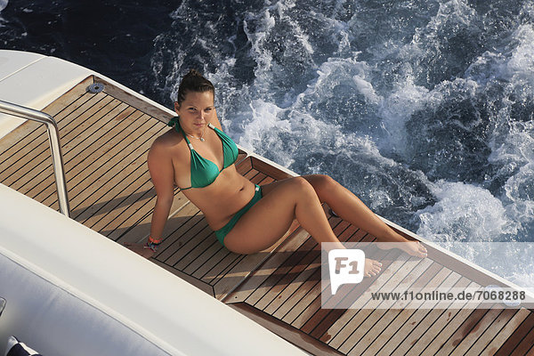 sitzend junge Frau junge Frauen bedecken Bikini Plattform grün Yacht Bewegung Kleidung schwimmen Teakholz