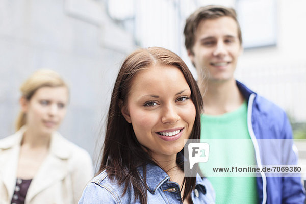 Portrait einer glücklichen Studentin mit Freunden im Hintergrund