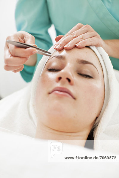 Junge Frau mit aus der Pinzette gezupften Augenbrauen im Beauty Spa
