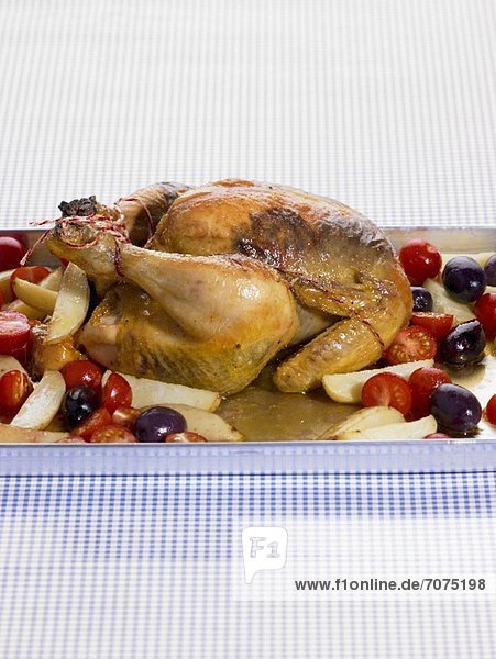 Roast chicken with potatoes  tomatoes and olives