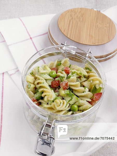 Pasta salad with vegetables in a jar for a picnic