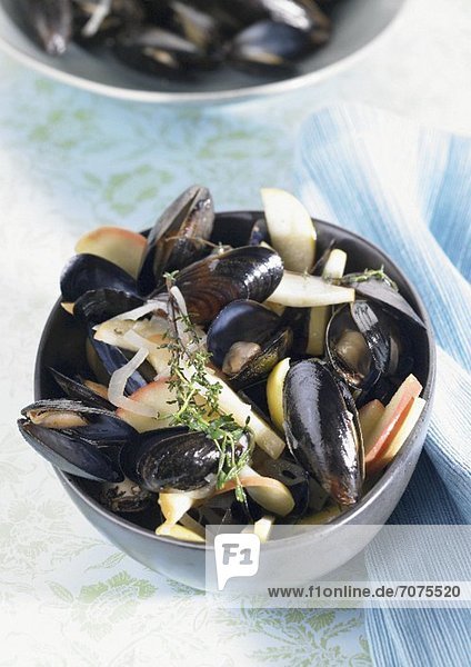 Mussels in broth with apple slices and thyme