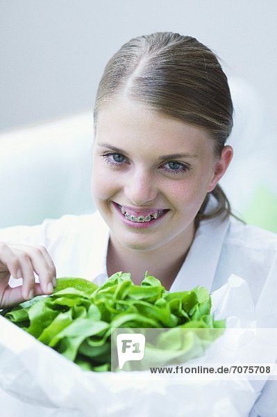Mädchen hält grünen Salat