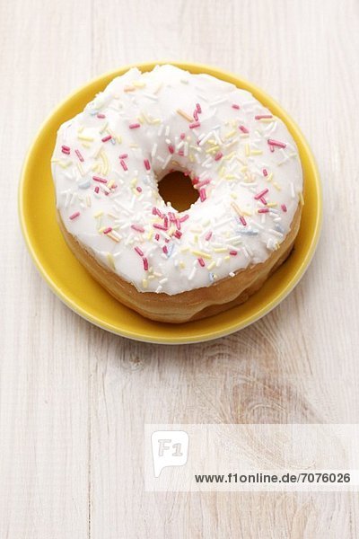 An iced doughnut with sugar sprinkles