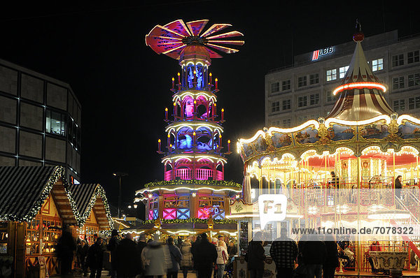 Christmas market on Alexanderplatz square with a children's merry-go-round and a Christmas pyramid  Berlin  Germany  Europe
