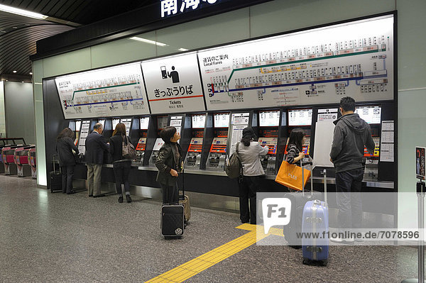 Ticket machines with a plan for the railway station above them with rates for purchasing tickets and a yellow guide strip for the visually impaired on the ground  Nambai Namba Railway Station in Osaka  Japan  East Asia  Asia