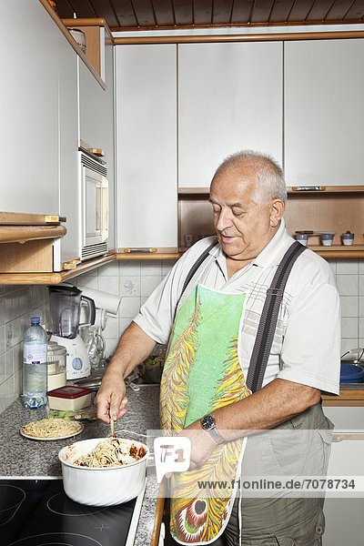 Elderly man cooking in the kitchen