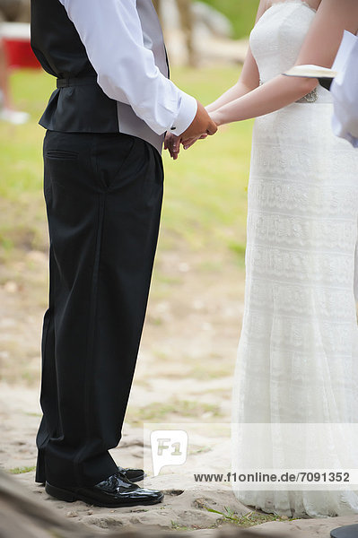USA  Texas  Bride and groom holding hands  close up