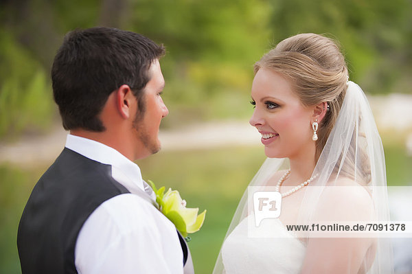 USA  Texas  Bride and groom looking at each other  smiling