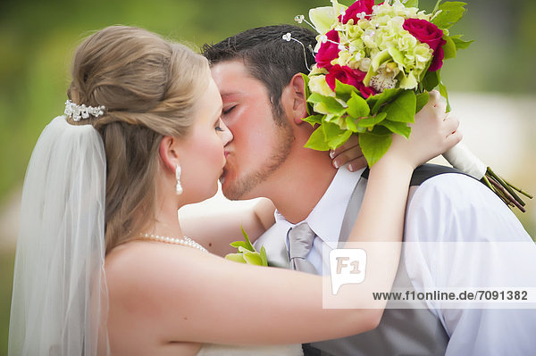USA  Texas  Bride and groom kissing on wedding day