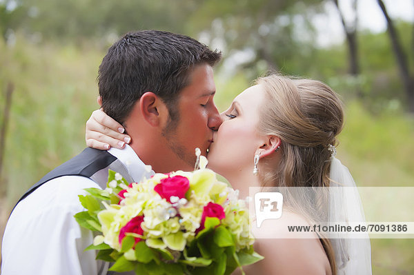 USA  Texas  Bride and groom kissing on wedding day