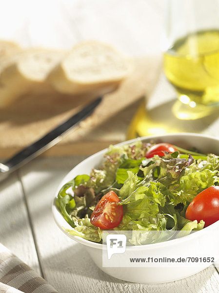 Gemischter Salat mit Brot und Olivenöl auf dem Tisch