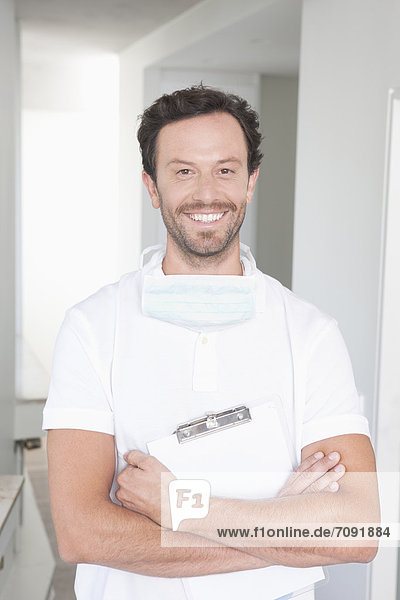 Germany  Dentist holding clip board  smiling  portrait