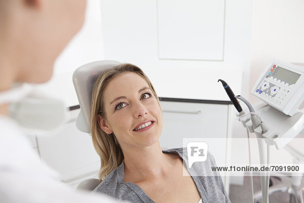 Germany  Mid adult woman in dentist chair  smiling