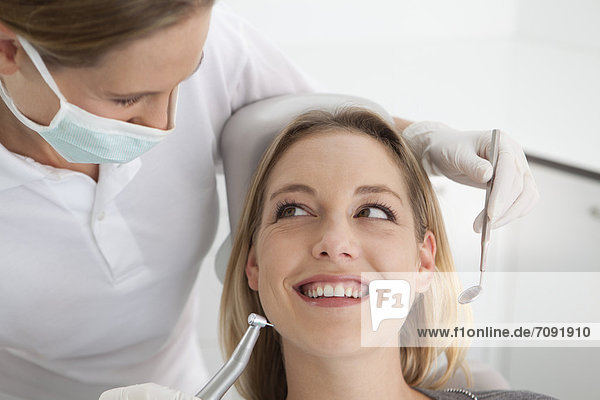 Germany  Young woman getting her teeth examined by dentist