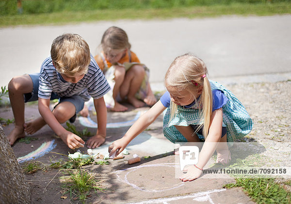 Germany  Bavaria  Group of children drawing on walkway with chalk