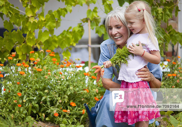 Mature woman with girl in garden
