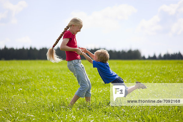 Boy and girl playing in meadow