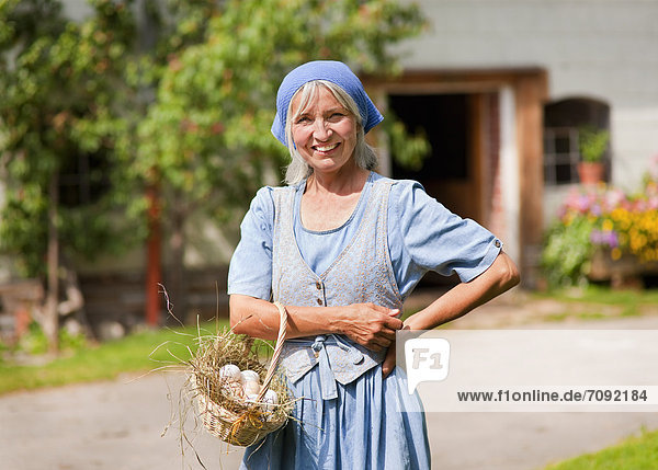 Mature woman with basket of fresh eggs