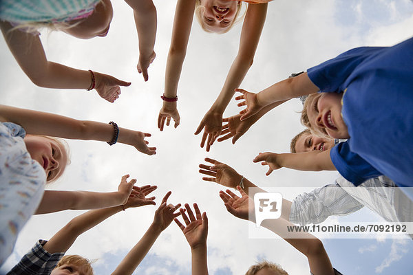 Germany  Bavaria  Group of children raising hands in air