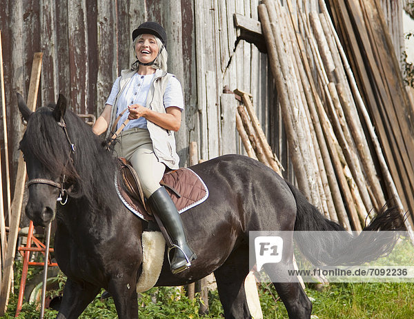 Mature woman riding horse