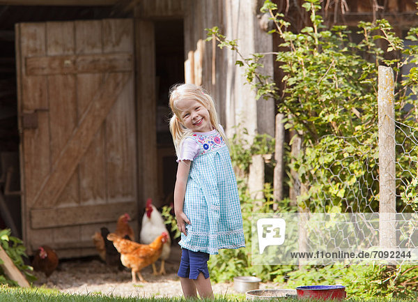 Girl with chicken on farm