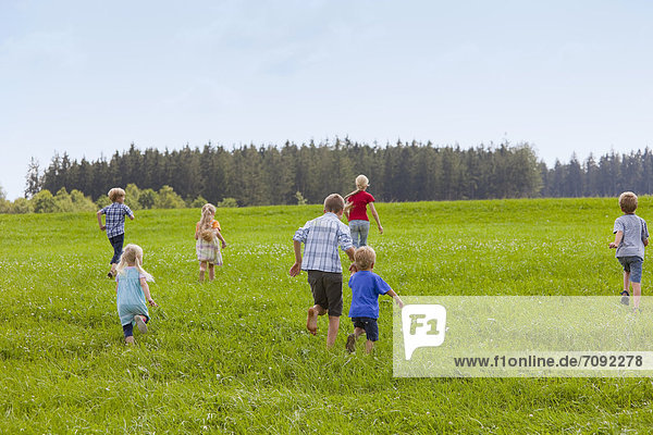 Germany  Bavaria  Group of children running through meadow