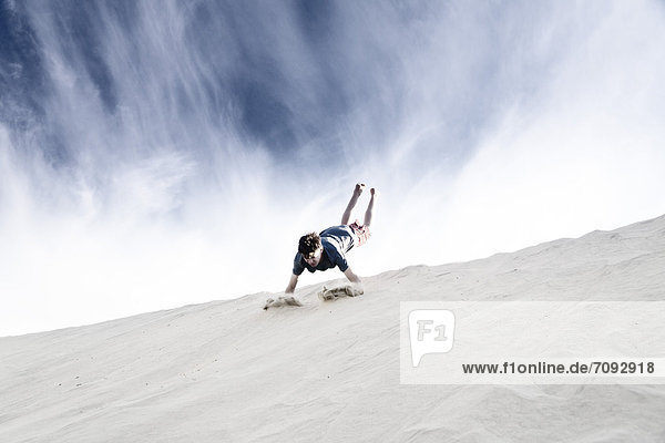 France  Boy jumping on sand dune