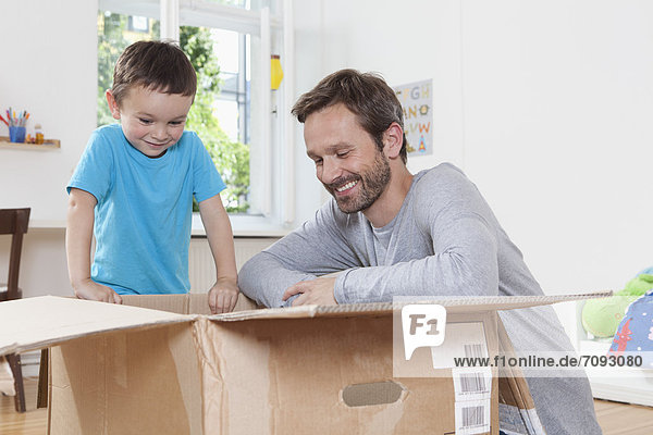 Germany  Berlin  Father and son opening parcel box