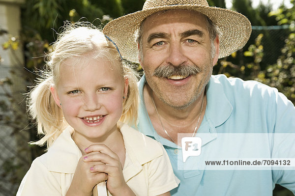 Germany  Bavaria  Grandfather and granddaughter smiling  portrait