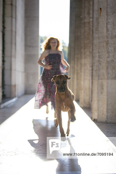 Frau und Hund rennen durch die Säulen der Walhalla  Donaustauf  Bayern  Deutschland  Europa