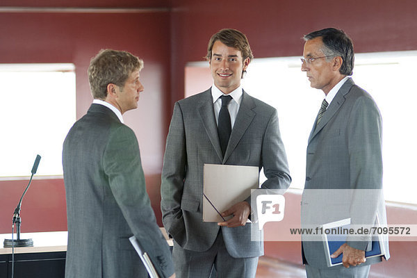 Young businessman talking with colleagues in office