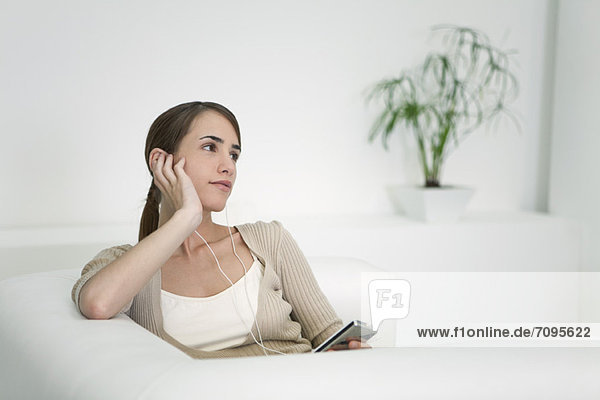 Young woman listening to MP3 player